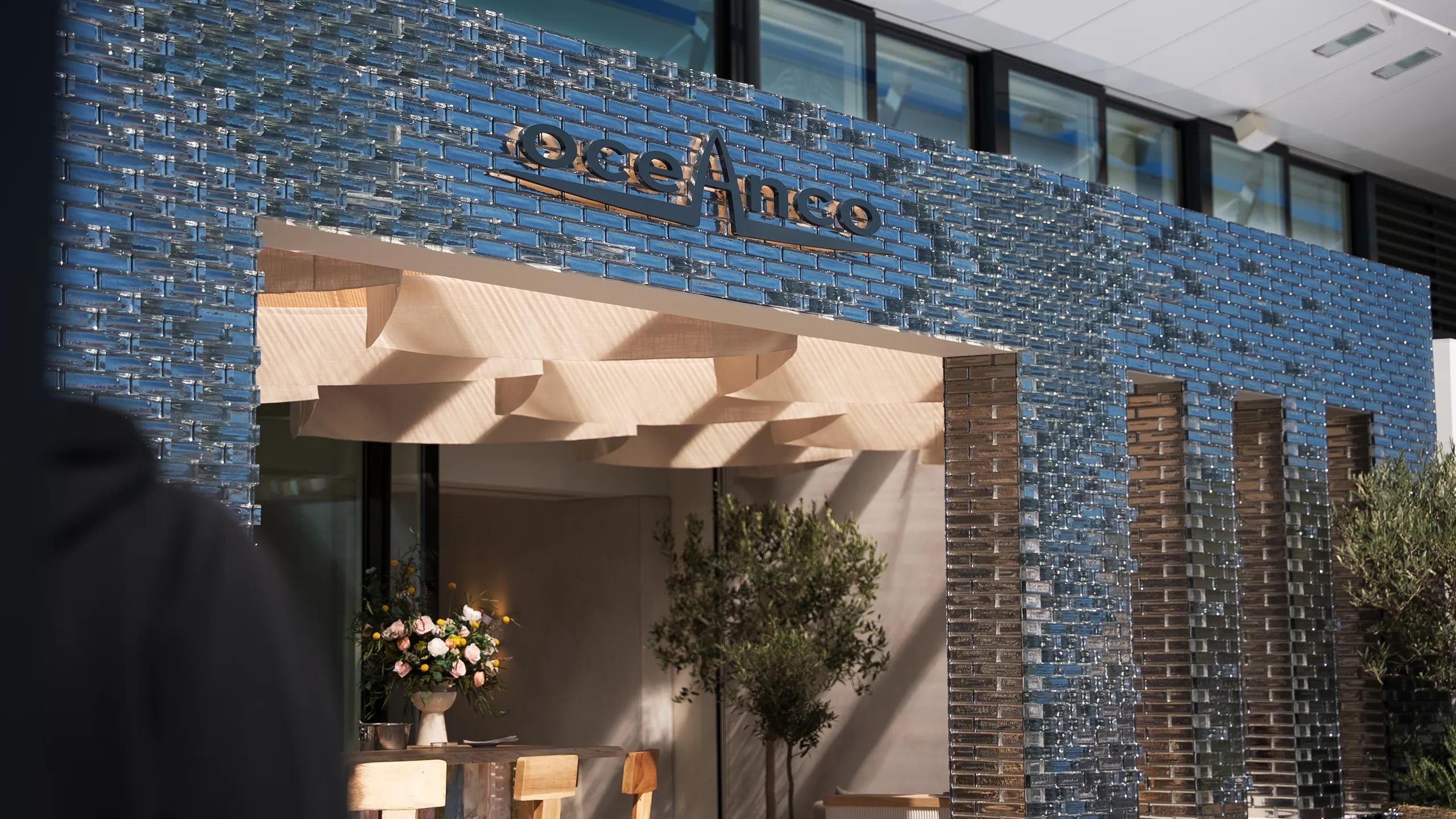 Detailphoto of entrance area of the Hypsos exhibition stand for Oceanco at the Monaco Yacht Show 2025 featuring glass tiles for a luxury finish